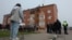 People gather outside a damaged residential building following a Ukrainian drone strike in the Ramensky district of the Moscow region.