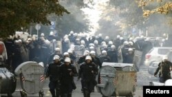 Riot police run down a street during clashes in Belgrade with antigay protesters on October 10.