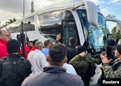 Njerëzit mblidhen pranë një autobusi që transporton të burgosur palestinezë të liruar nga një burg izraelit, si pjesë e një marrëveshjeje armëpushimi në Gazë midis Hamasit dhe Izraelit, në Bregun Perëndimor, 25 janar 2025.