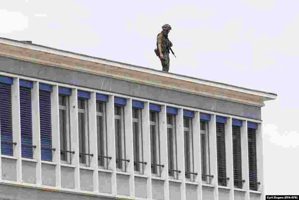 Солдат стоїть на даху будівлі біля аеропорту Женеви, 15 червня