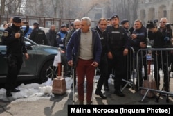 Călin Georgescu, adus la Parchetul General din București, 26 februarie 2025. Fostul candidat prezidențial din România se folosește de cârje după o operație la genunchi făcută în Germania, în urmă cu câteva zile.