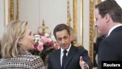 French President Nicolas Sarkozy (center) and British Prime Minister David Cameron (right) will host the Paris conference on Libya, which U.S. Secretary of State Hillary Clinton will also attend.