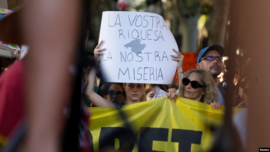 «Pasuria juaj, mjerimi ynë», shkruhet në një poster në Palma de Mallorca.