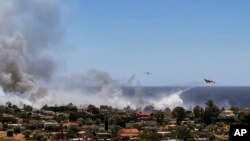 Zjarrfikësit duke shuar një vatër zjarri në Palaia Fokaia, në afërsi të Athinës. 26 qershor 2025. 