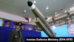 IRAN -- Iranian Defense Minister Amir Hatami stands next to a new generation of Iranian short-range missile 'Fateh-mobin' during an unveiling ceremony in Tehran, August 13, 2018