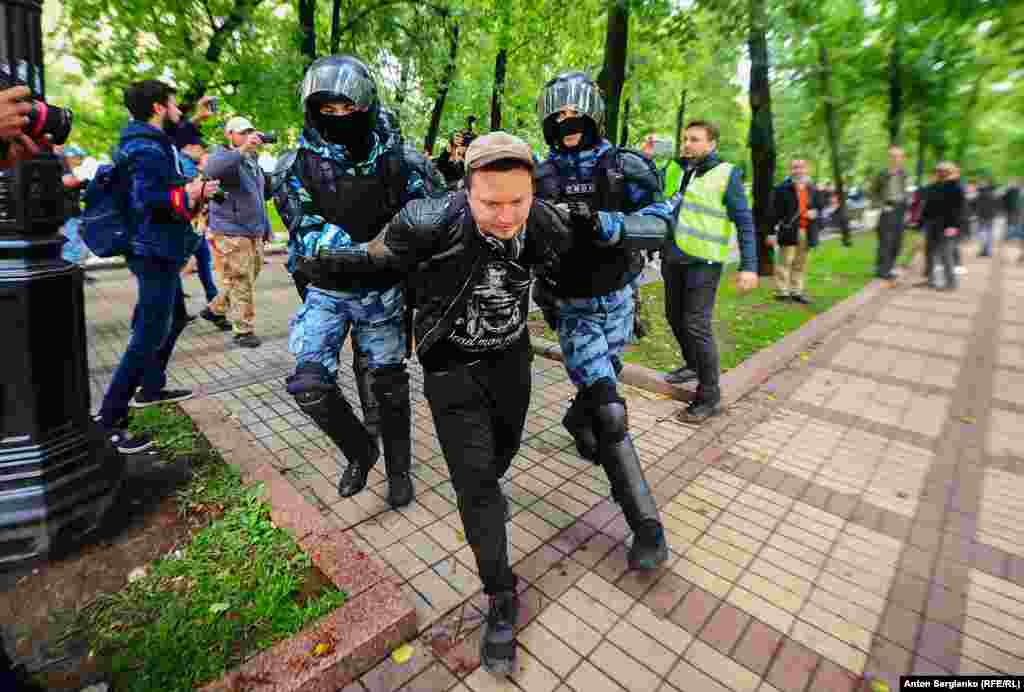 Russian police arrest a man following an opposition rally in Moscow on August 10. (RFE/RL / Anton Sergienko)