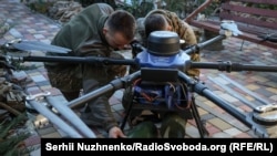 Ukrainian soldiers attach explosives to a Kazhan combat drone near Pokrovsk in the eastern Donetsk region.