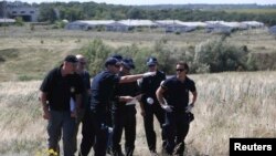 Група міжнародних експертів, включно з поліцейськими з Нідерландів, працює на місці падіння літака рейсу MH17, 1 серпня 2014 року