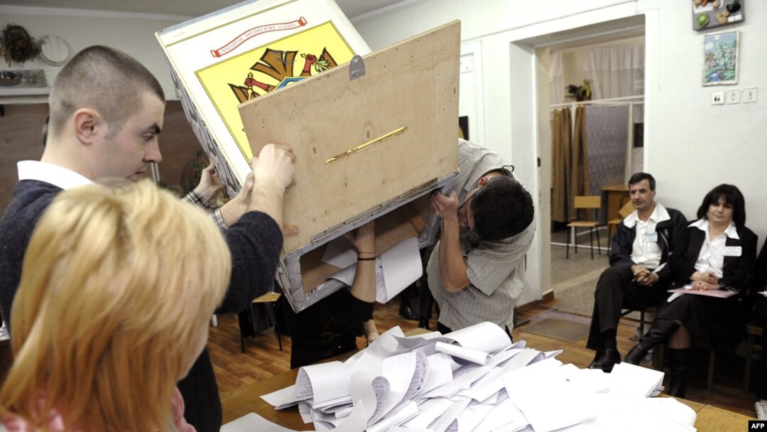 Members of a local election commission empty a ballot box in Chisinau on April 5