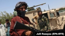 Afghan security officials and private militia members patrol on August 5 after taking back control of parts of Herat City following an intense battle with Taliban militants.