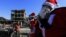 A Syrian child smiles as men dressed in Santa Claus costumes walk past destroyed buildings in the eastern Syrian city of Raqqa on December 26.