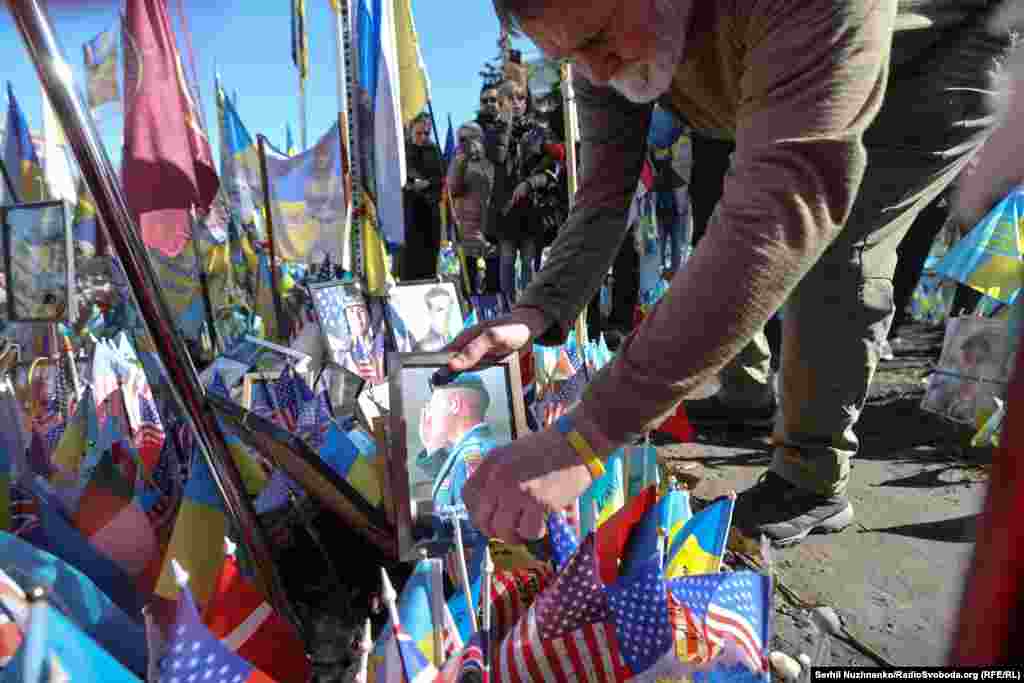 Bill Cole places a portrait of Andrew Webber, a decorated US military veteran who was killed in July 2023 in eastern Ukraine.