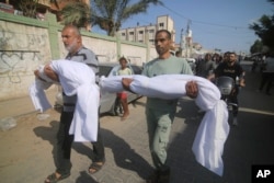 Жители города Хан-Юнис на юге сектора Газа несут тела своих родственников, погибших в результате израильского удара. 10 октября 2023 года