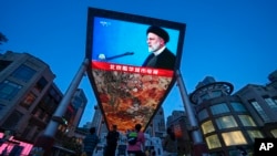 A large screen shows a report on Iranian President Ebrahim Raisi's death at an outdoor shopping mall in Beijing on May 20.