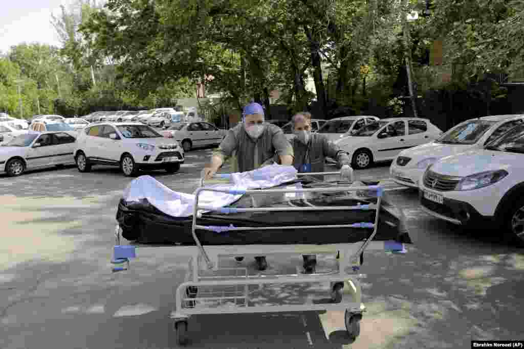 Hospital workers move the bodies of two patients who died from COVID-19.