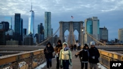 Disa qytetarë duke kaluar në urën Bruklin në Qytetin e Nju Jorkut më 21 janar. Guvernatorja e Nju Jorkut paralajmëroi se stuhia e borës mund të jetë "vdekjeprurëse". 