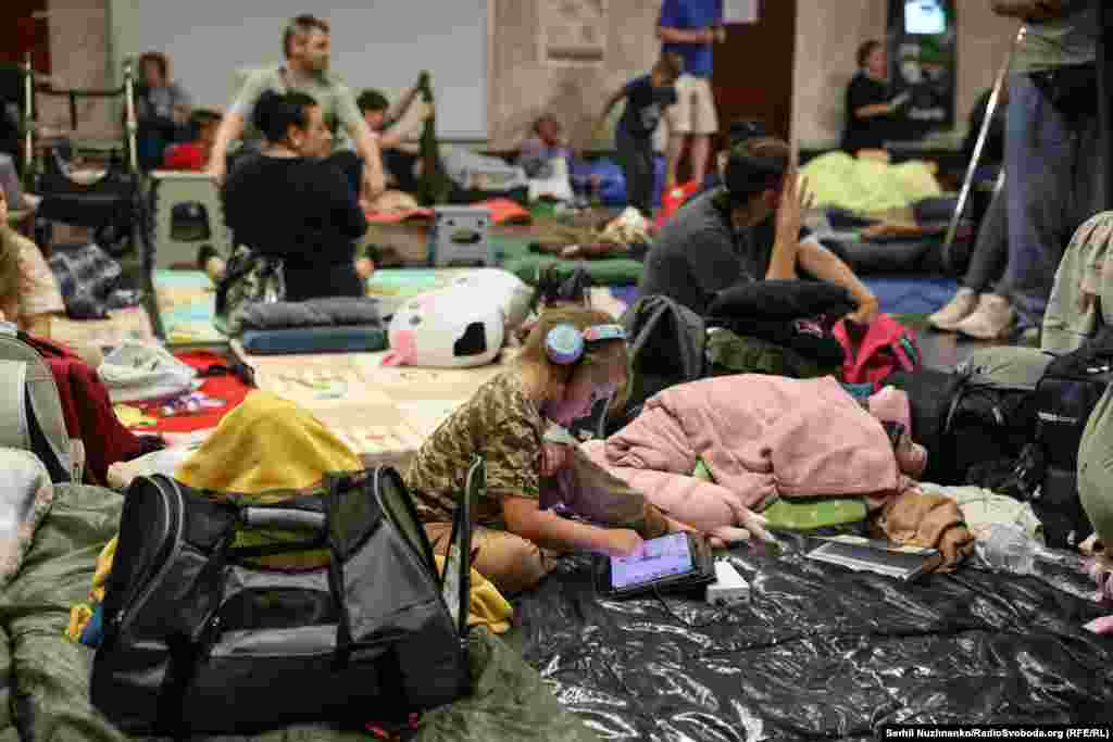 Дитина в київському метрополітені під час масованої російської ракетної атаки. Київ, 18 липня 2025 року. Під час повітряних тривог метро перетворюється на укриття для тисяч людей. Оскільки російська армія цілеспрямовано ночами атакує українську столицю, то кияни цілими родинами сплять у метро на матрацах, накрившись ковдрами. Беруть з собою також домашніх тварин