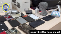 Мабільныя тэлефоны, выкладзеныя на стол пры ператрусе ў махлярскіх цэнтрах