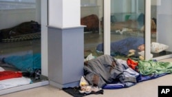 Migránsok alszanak egy foglalt házban Brüsszelben 2023. január 31-én