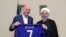 A handout picture released by the office of Iranian President Hassan Rouhani shows him (R) and FIFA President Gianni Infantino holding a jersey with Rouhani's name during Infantino's visit to the capital Tehran on March 1, 2018.