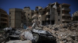 A damaged building, rubble, and a destroyed vehicle in the aftermath of Israeli strikes near Hiram Hospital in Tyre, south Lebanon, on April 16