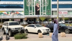 A man walks past a banner of Saudi Crown Prince Mohammed bin Salman displayed on a commercial building in Riyadh. 