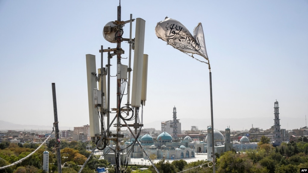 A Taliban flag flutters near telecom equipment installed over a rooftop providing Internet services in Balkh Province on September 16.