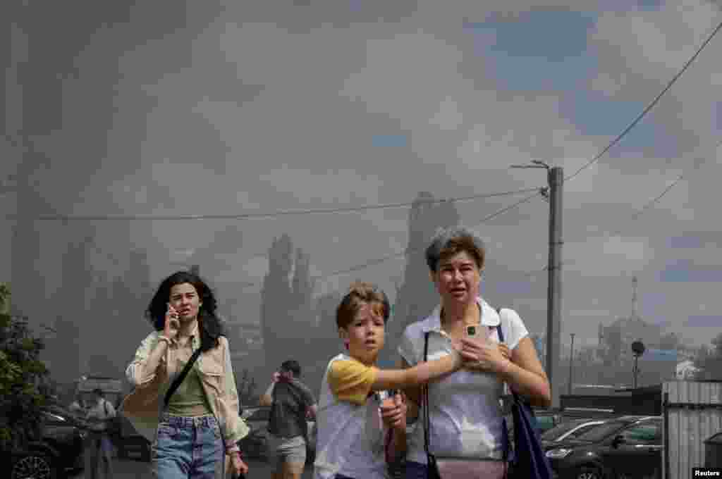 Residents leave the site of a Russian air strike in Kharkiv in northeastern Ukraine.
