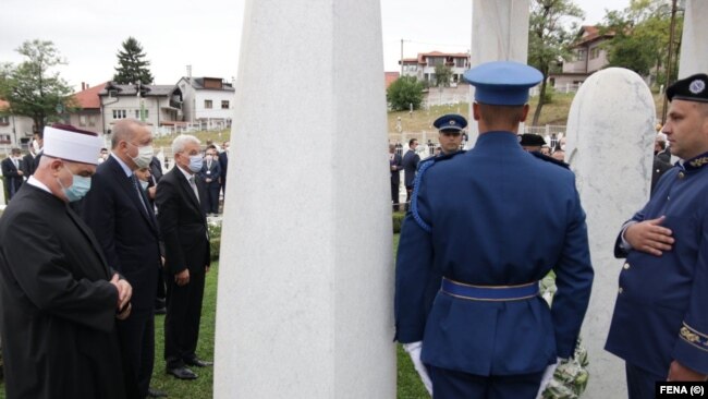 Erdogan u društvu reisu-l-uleme Islamske zajednice u BiH Huseina ef. Kavazovića (prvi slijeva) i člana Predsjedništva BiH Šefika Džaferovića (treći slijeva), odaje poštu Aliji Izetbegoviću na mezarju Kovači, Sarajevo (27. avgust 2021.)