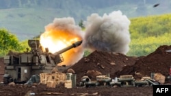 An Israeli self-propelled artillery gun fires rounds toward southern Lebanon on March 15.