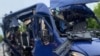 A mangled minibus on a road in Ukraine's Sumy region, where Ukrainian authorities say a Russian drone strioke killed nine people on May 17.
