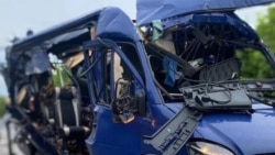 A mangled minibus on a road in Ukraine's Sumy region, where Ukrainian authorities say a Russian drone strioke killed nine people on May 17.