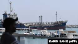 UAE -- A man watches on July 2, 2019 the ships movement in the port of Fujairah in the east of the United Arab Emirates (UAE), where recent tensions spiraling between Iran and the United States have affected movement in the Gulf of Oman, near the strategi