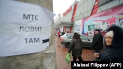 Жители в надежде поймать сигнал от сотовых вышек звонят в районе, где в листовке говорится: «МТС ловит там». Донецк, 2 февраля 2018 года