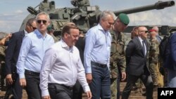 Secretarul general al NATO Jens Stoltenberg (stânga), președintele Lituaniei Gitanas Nauseda și ministrul german al apărării Boris Pistorius (dreapta) vizitează soldații care participă la exercițiul militar bilateral lituano-german „Griffin Storm”, Lituania, la 26 iunie 2023.
