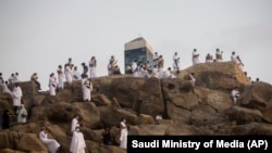 Мусульманские паломники молятся на вершине скалистого холма, известного как Гора Милосердия на равнине Арафат, июль 2020 года.