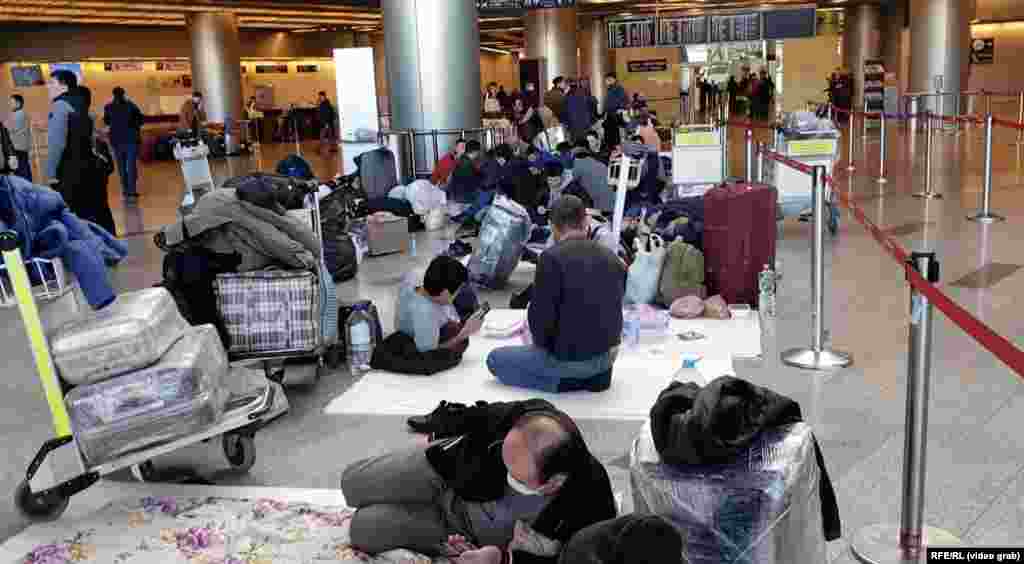 Uzbek migrant workers sprawl out on the floor at Vnukovo International Airport outside Moscow.