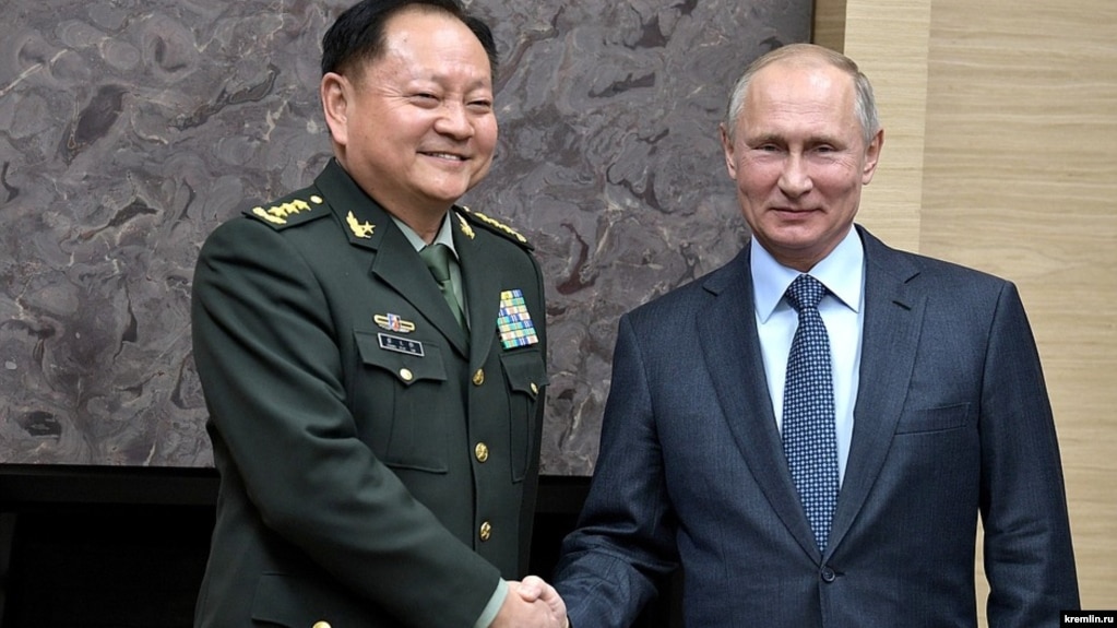 Ресей президенті Владимир Путин (оң жақта) елге сапармен келген қытай генералы Чжан Юсямен қол алысып тұр. 2017 жыл.