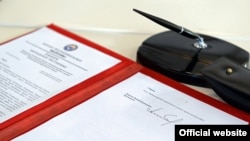 Кыргызстандын ЕАЭБге кирүүсү тууралуу президент Алмазбек Атамбаев кол койгон мыйзам. 29-май, 2015-жыл.