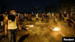 Demonstrators defy a curfew to protest on the streets of Baghdad on October 3.