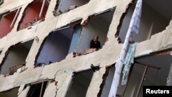 A woman looks out from a damaged building after a suspected car bomb in Diyarbakir on November 4.