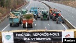 „Macron, răspunde-ne!”, îndeamnă participanții la blocada de pe o autostradă franceză, lângă Paris, la 30 ianuarie. 