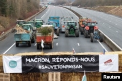 „Macron, răspunde-ne!”, este inscripția de pe un banner afișat în timpul unui protest al fermierilor din Franța, care s-au alăturat fermierilor protestatari din întreaga Europă, nemulțumiți de creșterea taxelor și de noile reglementări ecologice ale UE, Paris, 30 ianuarie 2024.