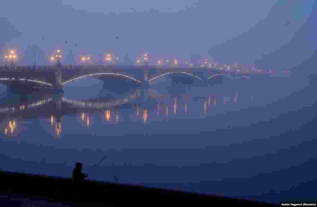 A man fishes near Troitsky Bridge on a foggy morning in St. Petersburg, Russia. (Reuters/Anton Vaganov)