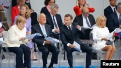 German Chancellor Angela Merkel, (from left) Portuguese President Marcelo Rebelo de Sousa, French President Emmanuel Macron, and his wife, Brigitte Macron, attend the traditional Bastille Day military parade on the Champs-Elysees Avenue in Paris on July 14.