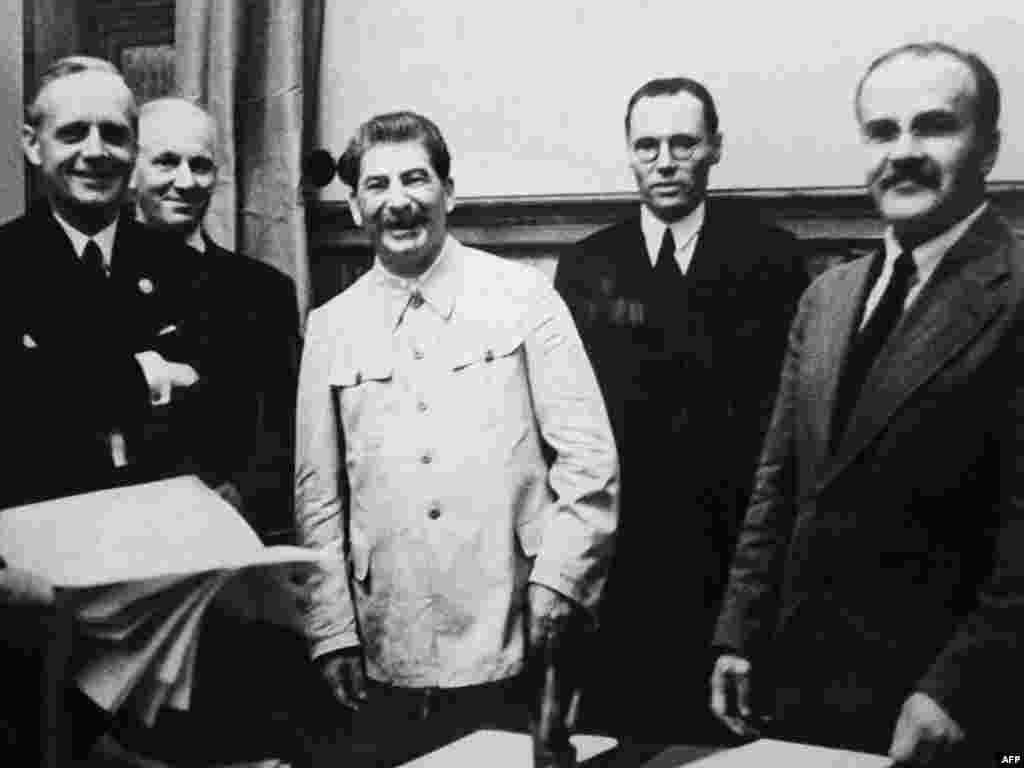 გერმანიის საგარეო საქმეთა მინისტრი იოახიმ ფონ რიბენტროპი (მარცხნივ), საბჭოთა კავშირის ლიდერი იოსებ სტალინი და საბჭოთა საგარეო საქმეთა მინისტრი ვიაჩესლავ მოლოტოვი (მარჯვნივ) ერთმანეთს კრემლში ხვდებიან თავდასუხმელობის პაქტზე ხელის მოსაწერად. 1939 წლის 23 აგვისტო.&nbsp;