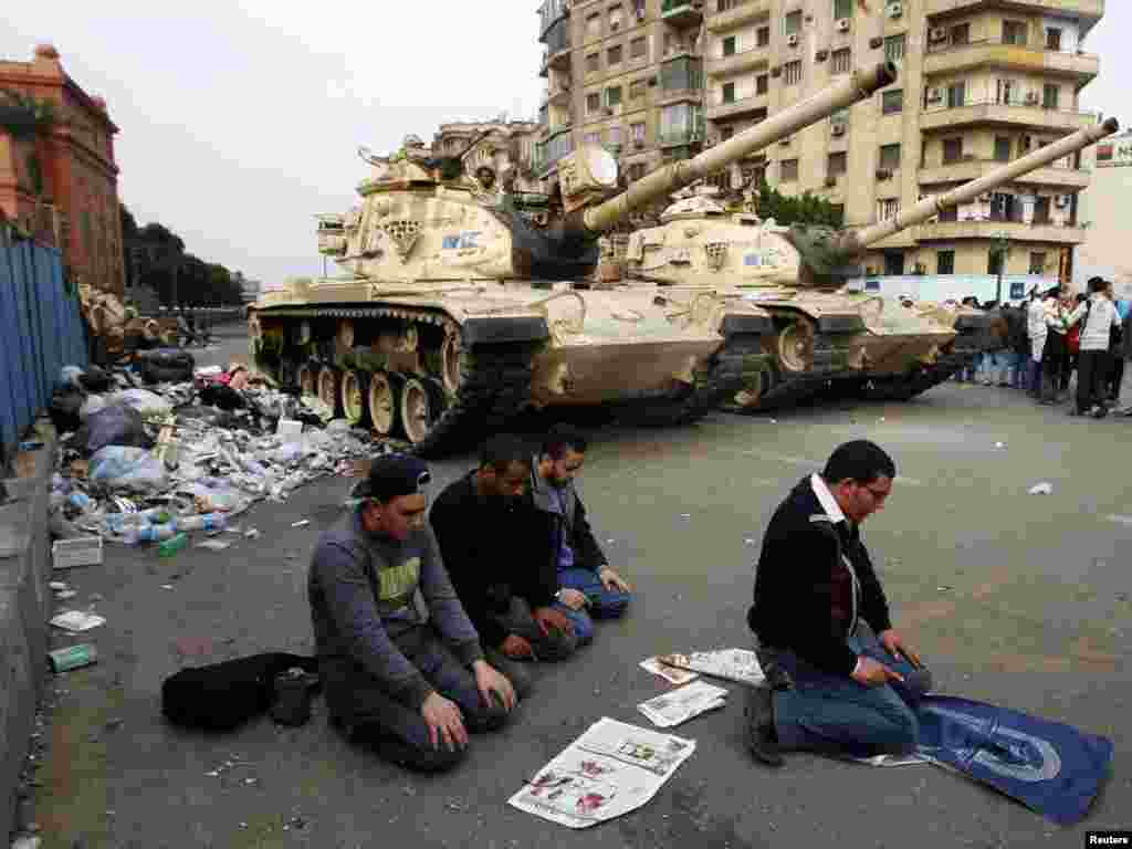 Protesters pray in front of army tanks during a mass demonstration against the government in Tahrir Square in Cairo on February 1. Photo by Yannis Behrakis for Reuters