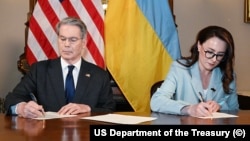 Ministrul american de finanțe, Scott Bessent, și prim-viceprim-ministra ucraineană, Iulia Sviridenko, semnând acordul privind mineralele, Washington, 30 aprilie 2025 