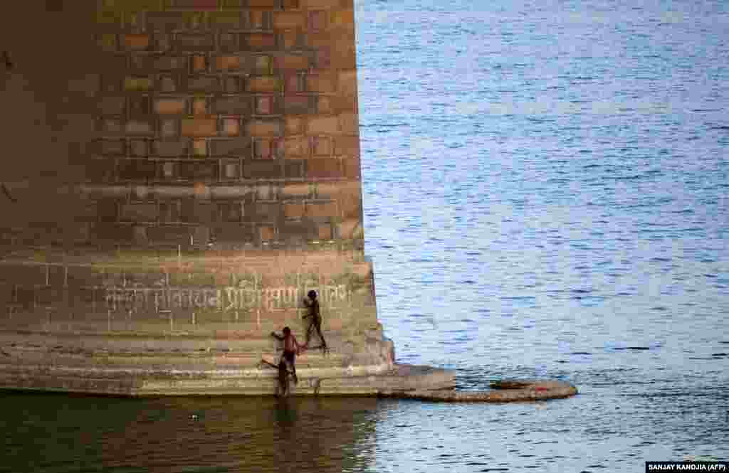 Indian children search under a railway bridge for coins offered by Hindu devotees in passing trains on the Yamuna River in Allahabad. (AFP/Sanjay Kanojia)