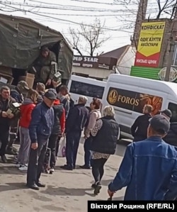 На місцевому ринку Мелітополя окупанти за 100 гривень продавали продуктові набори армії РФ. Люди вишукувались в чергу. Квітень 2022 року